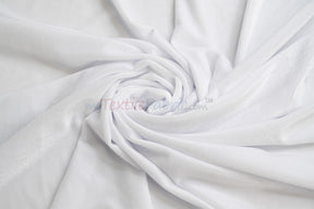 White soft and plush stretch velvet spandex fabric draped in swirls.