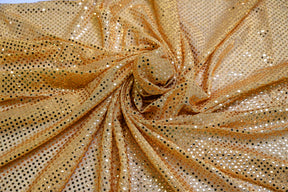 Gold confetti dot sequins fabric draped in folds for costume and cosplay decoration.
