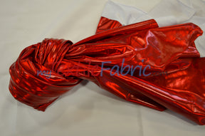 Red metallic foil spandex twisted in a knot with a white backing peeking through