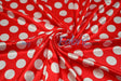 Red satin with white polka dots swirled to show sheen and drape