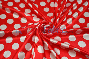 Red satin with white polka dots swirled to show sheen and drape